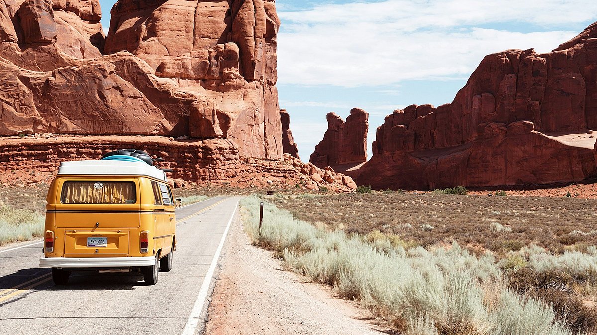 Gelber VW-Bus fährt auf einer Straße