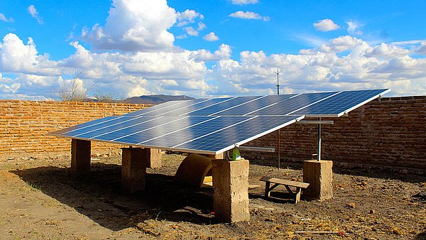 Wenige Solarpanels montiert auf trockenem, steinigen Boden 