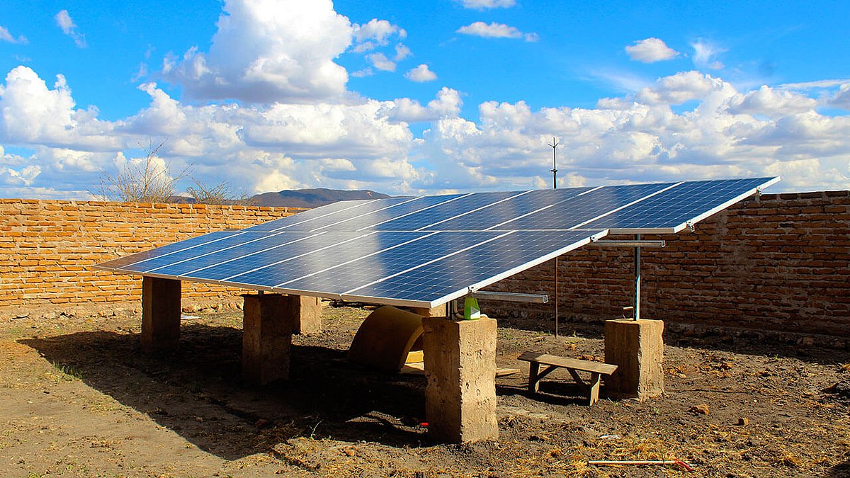 Wenige Solarpanels montiert auf trockenem, steinigen Boden 