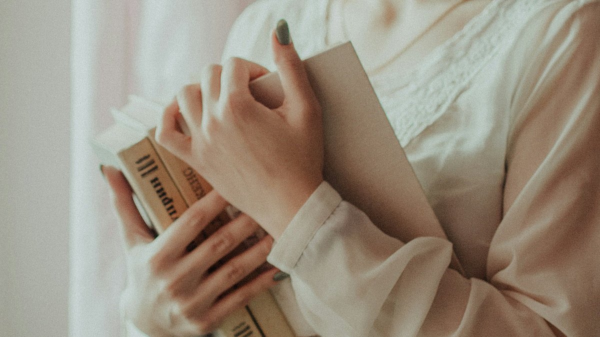 Frau hält Bücher in den Händen