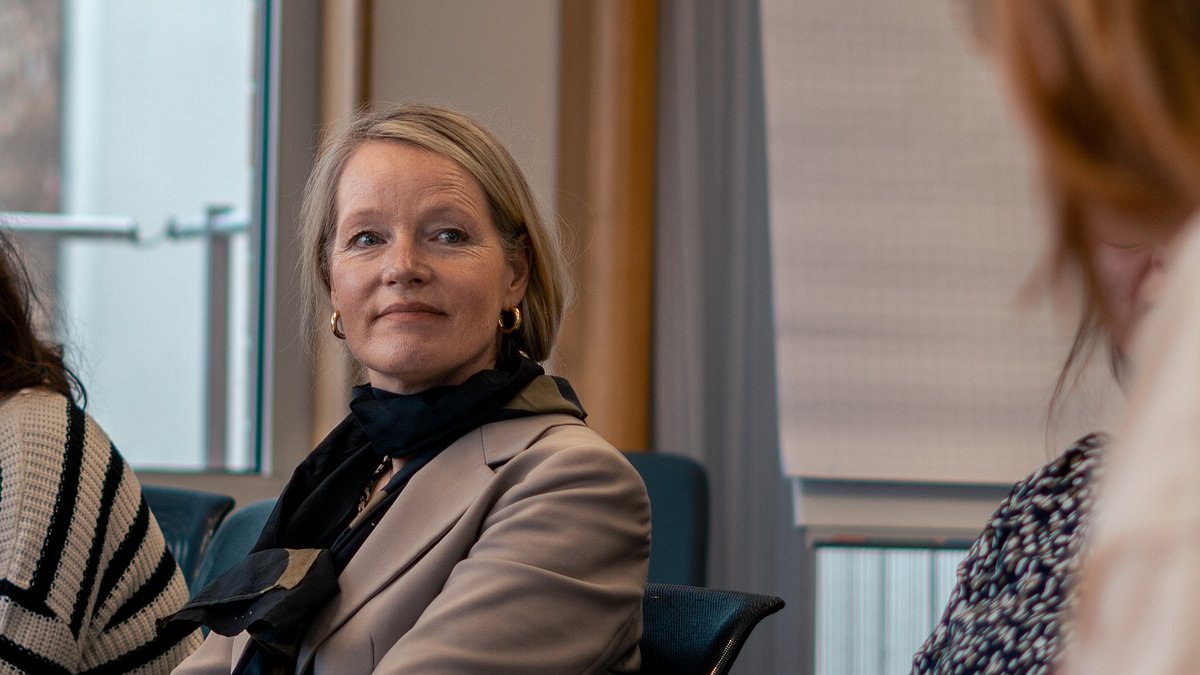 Thekla Walker spricht mit einer Gruppe Menschen.