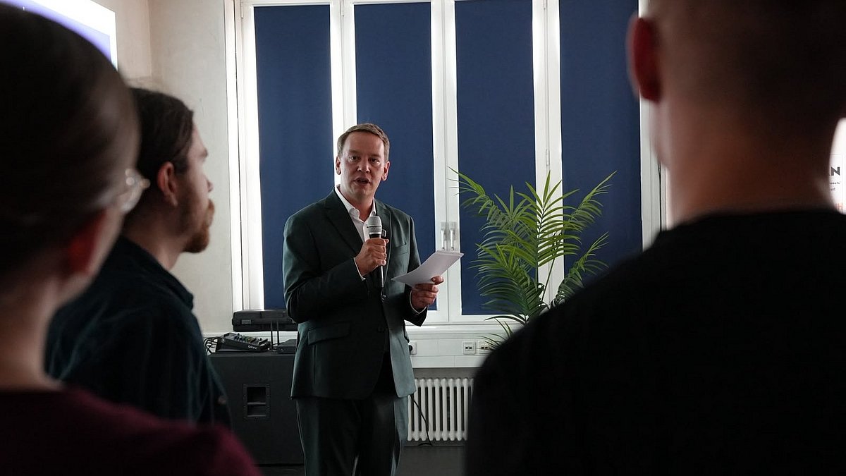 Jugend- und Sozialminister Oliver Hildenbrand spricht zu jungen Menschen und Landtagsabgeordneten