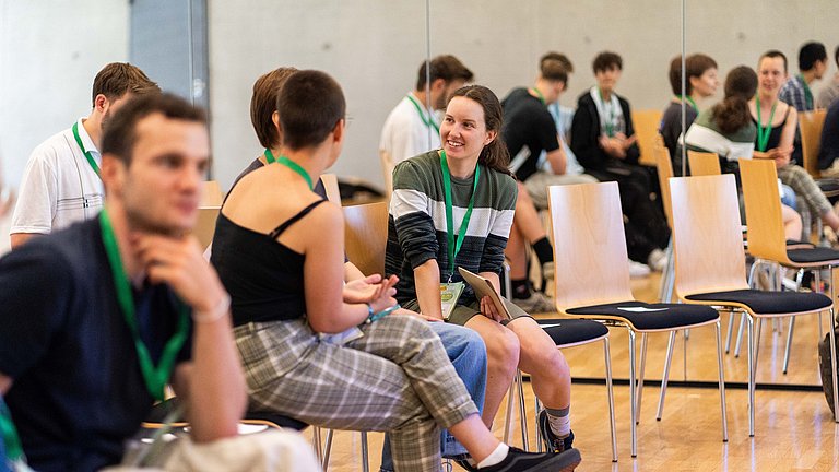 Junge Menschen unterhalten sich auf einer Bildungsveranstaltung.