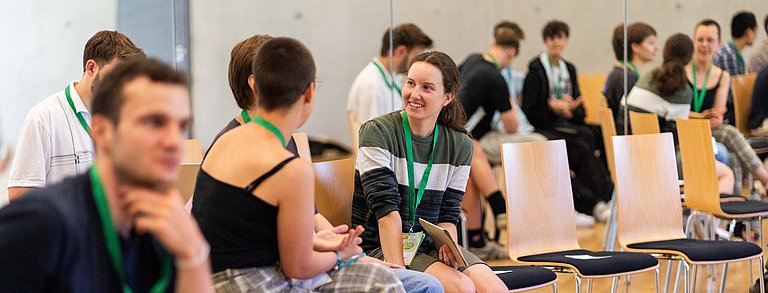 Junge Menschen unterhalten sich auf einer Bildungsveranstaltung.
