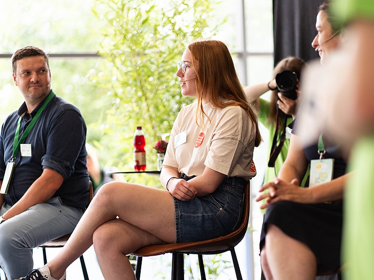 Diskussion auf einem Podium zwischen jungen Menschen