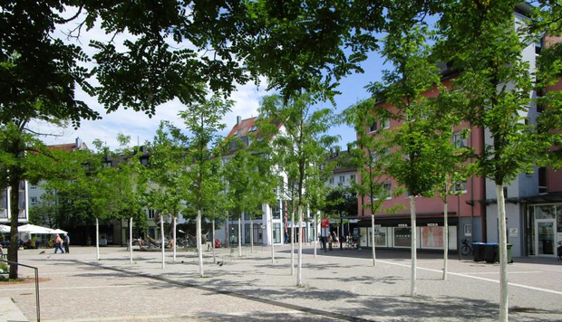 Städtischer Platz mit Bäumen und Begrünung