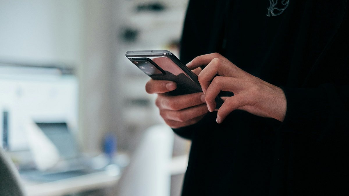 Ein Mensch hat sein Smartphone in der Hand