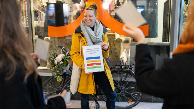 Eine junge Frau zeigt während einer Stadttour ein Papier.