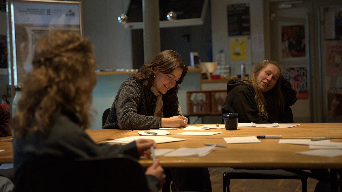 Gruppe sitzt am Tisch und denkt nach