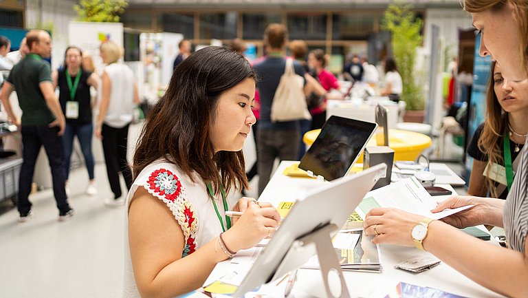 Frau informiert sich an einem Infostand