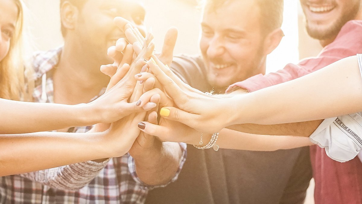 Glückliche Menschen führen ihre Hände zusammen