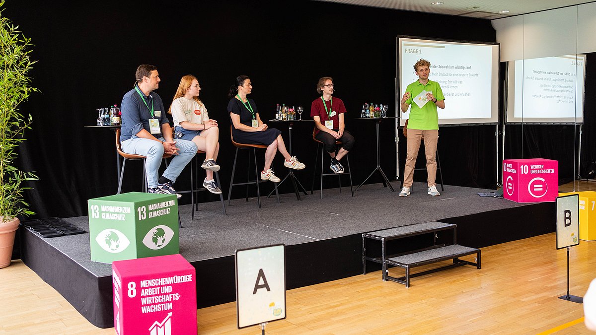 Julian von der Jungen Plattform der Nachhaltigkeitsstrategie moderiert das Impulsformat VOTE & DISCUSS zum Thema „Welchen Impact hat meine Berufswahl?“