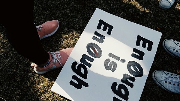 Ein Plakat auf dem Boden mit der Aufschrift "enough is enough"