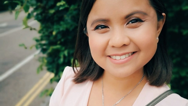 Ein Proträtfoto vor einer Hecke.