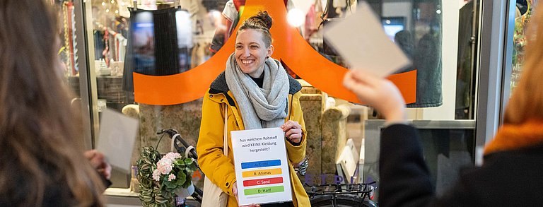Junge Frau hält eine Umfrage in der Hand bei einem Workshop