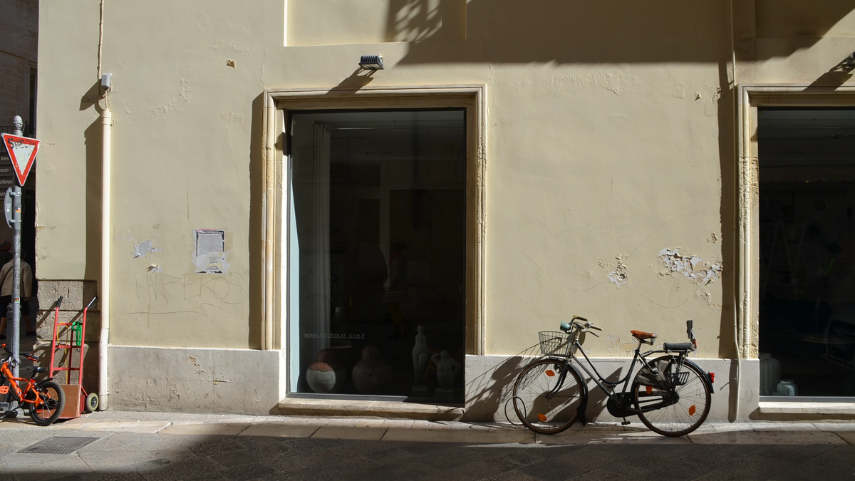 altes Fahrrad mit Kindersitz vor einer grün-gräulichen Hauswand