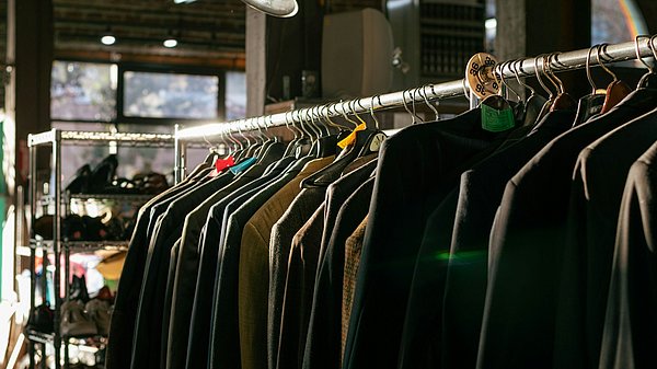 Kleidungsstücke hängen auf einer Stange 