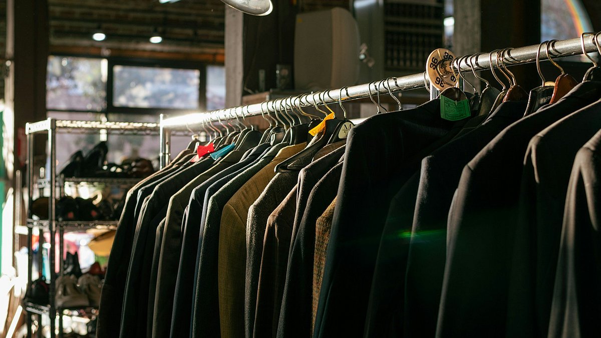 Kleidungsstücke hängen auf einer Stange 