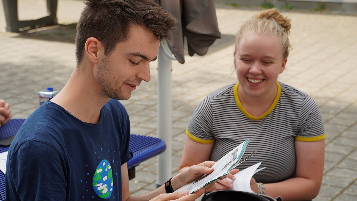 Zwei junge Menschen sitzen zusammen und unterhalten sich