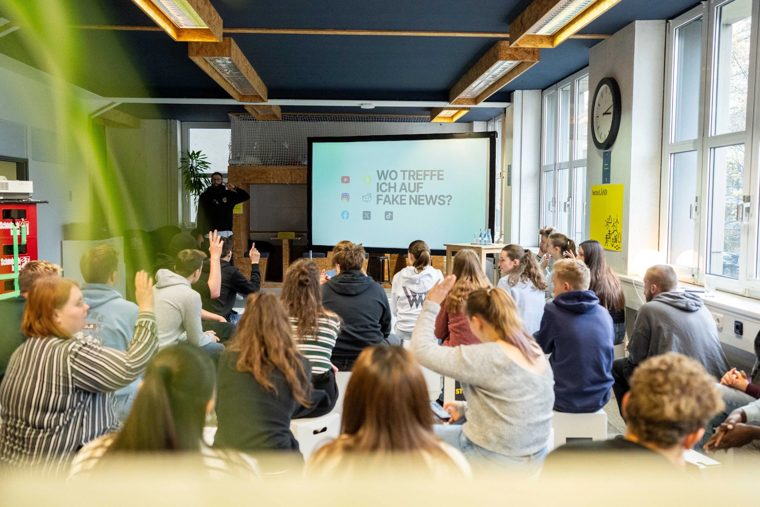 Junge Menschen hören einem Vortrag zu. 